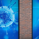 A man wearing a protective face mask walks past an illustration of a virus outside Oldham Regional Science Centre on November 24, 2020 in Oldham, United Kingdom.